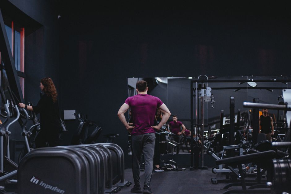 Gym member walking across the gym floor between weight stations