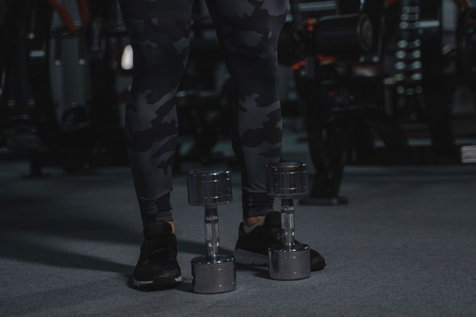 Close-up of a row of dumbbells on a rack in moody gym light